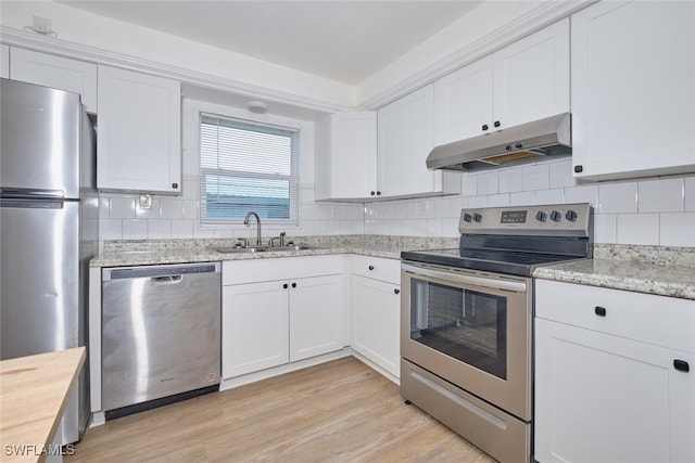 kitchen featuring stainless steel appliances, white cabinetry, sink, and light hardwood / wood-style flooring