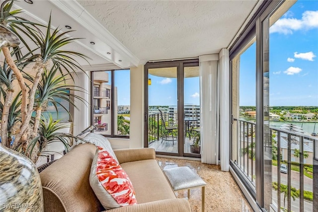 sunroom featuring a water view