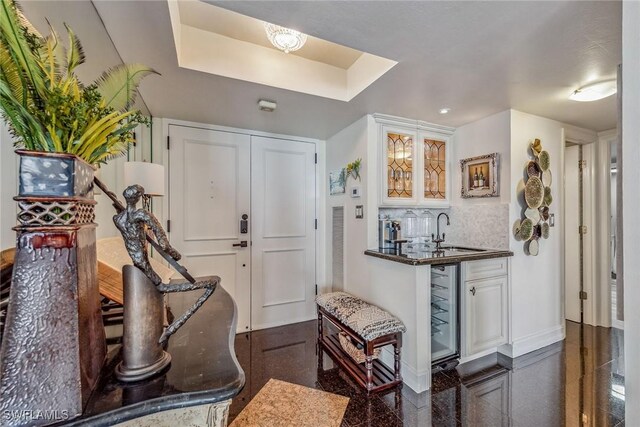 foyer entrance featuring wet bar and beverage cooler