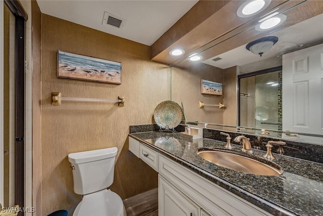 bathroom featuring vanity, an enclosed shower, and toilet