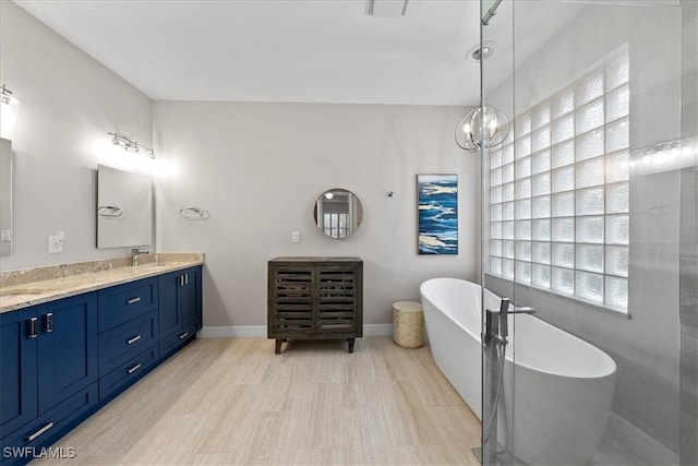 bathroom featuring vanity, plenty of natural light, wood-type flooring, and a bathtub