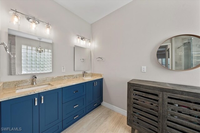 bathroom featuring a shower with door, vanity, wood-type flooring, and lofted ceiling