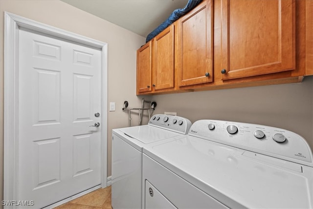 laundry room featuring cabinets, separate washer and dryer, and light tile patterned flooring