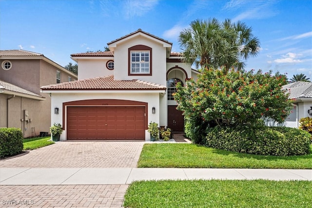 mediterranean / spanish-style house featuring a garage and a front lawn