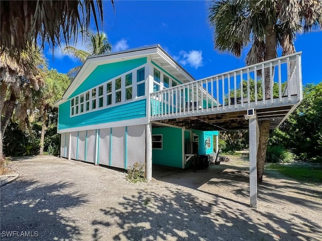 4570 Escondido Ln, Upper Captiva, FL 33924 - view of front of house featuring asphalt driveway, a deck, and a carport