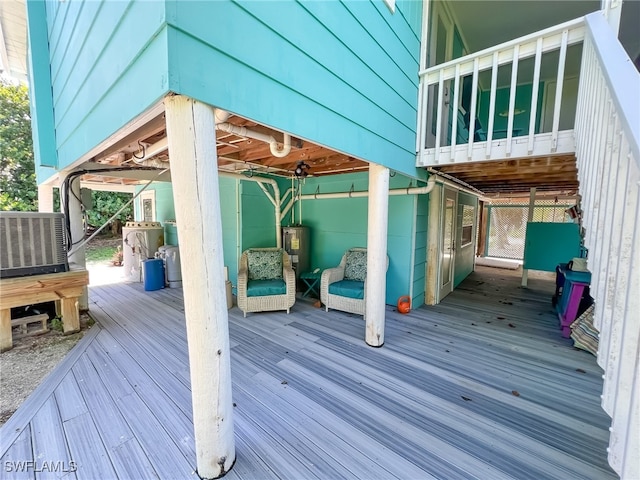 wooden deck featuring electric water heater and cooling unit