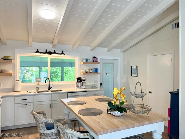 kitchen featuring hardwood / wood-style floors, wooden counters, lofted ceiling with beams, sink, and white cabinetry