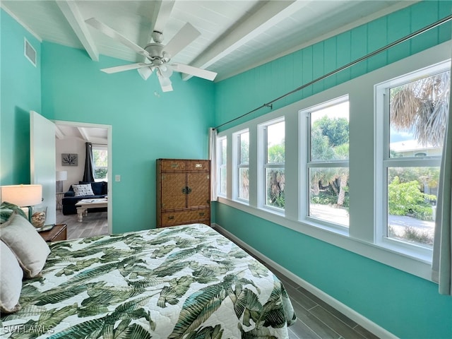 bedroom featuring beamed ceiling, ceiling fan, and wood-type flooring