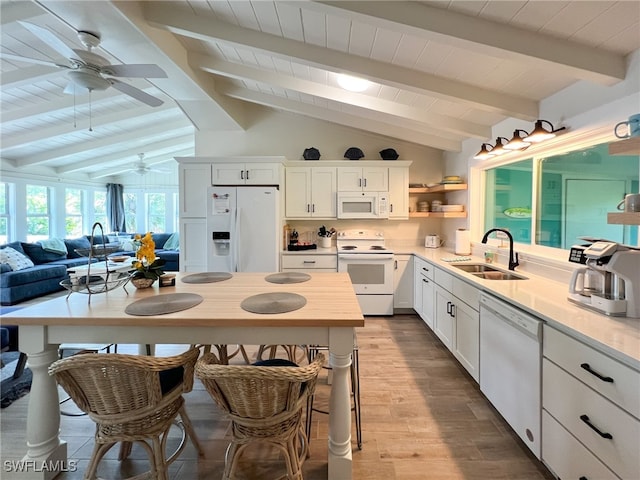 kitchen with white appliances, lofted ceiling with beams, white cabinetry, and sink