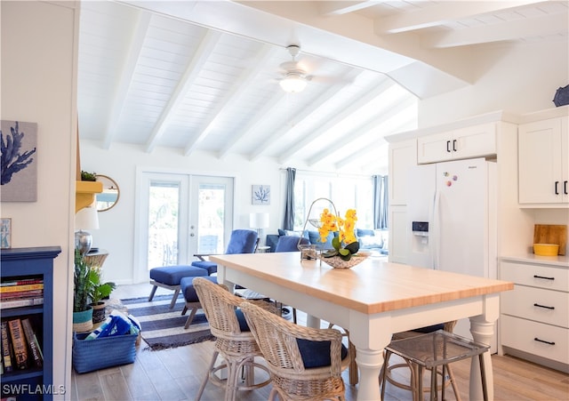 dining space featuring french doors, vaulted ceiling with beams, light hardwood / wood-style floors, and ceiling fan