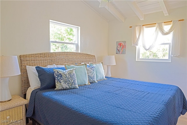 bedroom featuring multiple windows and vaulted ceiling with beams