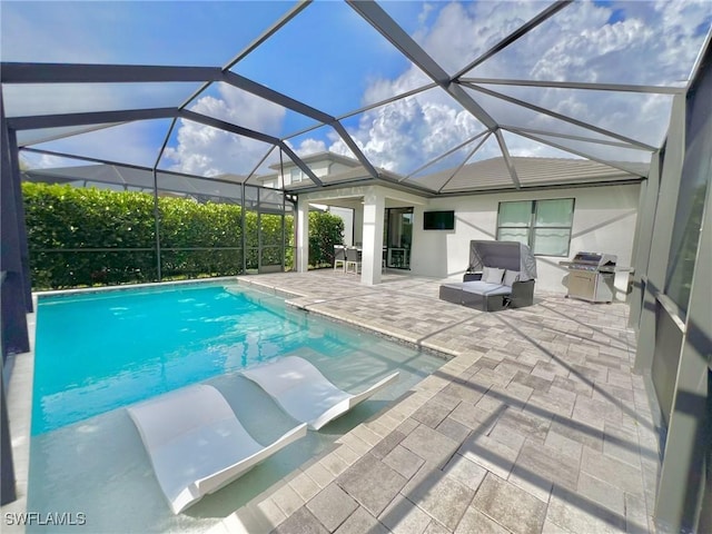 view of pool with area for grilling, a patio, and glass enclosure