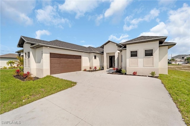 prairie-style home featuring a garage, driveway, a front lawn, and stucco siding