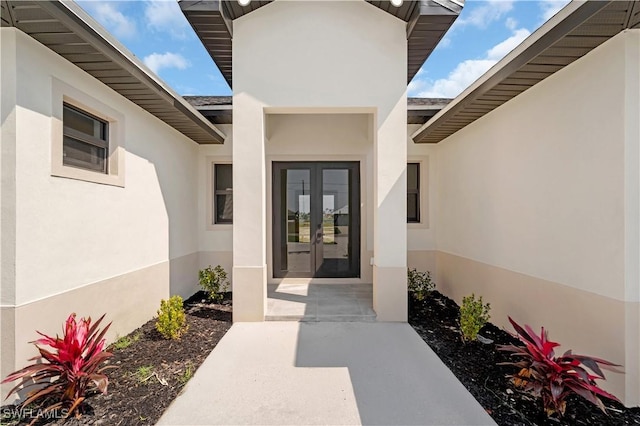 property entrance featuring french doors and stucco siding