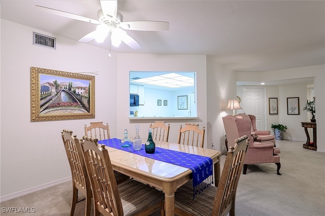 carpeted dining area featuring ceiling fan