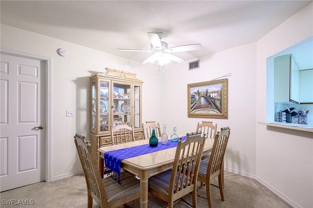 carpeted dining room with ceiling fan