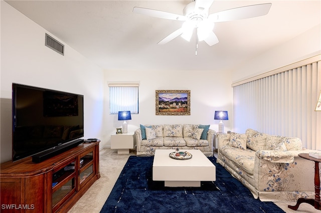 carpeted living room with ceiling fan