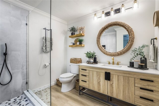 bathroom featuring vanity, an enclosed shower, hardwood / wood-style floors, toilet, and ornamental molding