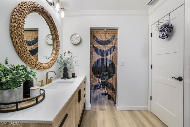 interior space featuring hardwood / wood-style flooring, crown molding, and vanity