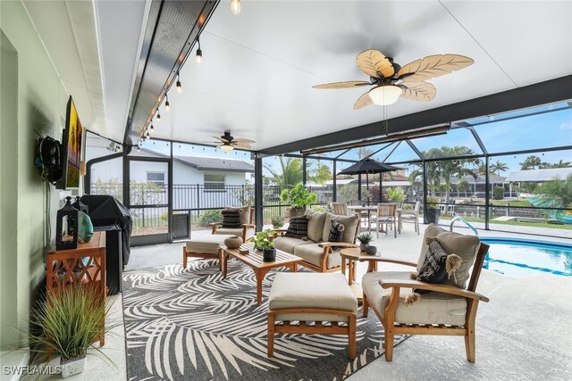 sunroom with ceiling fan and a swimming pool