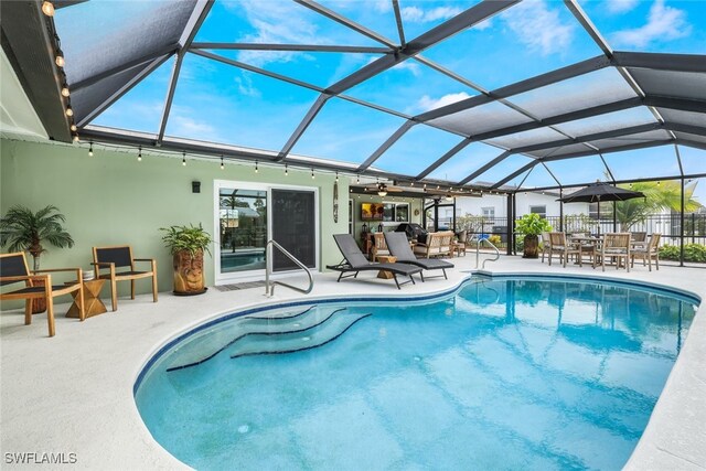 view of swimming pool featuring a lanai and a patio area