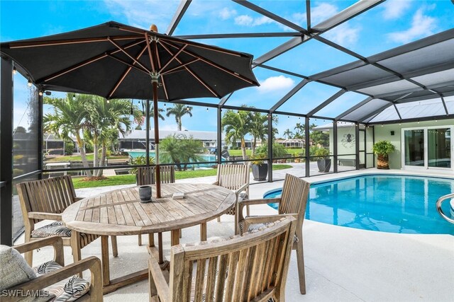 view of pool with glass enclosure and a patio