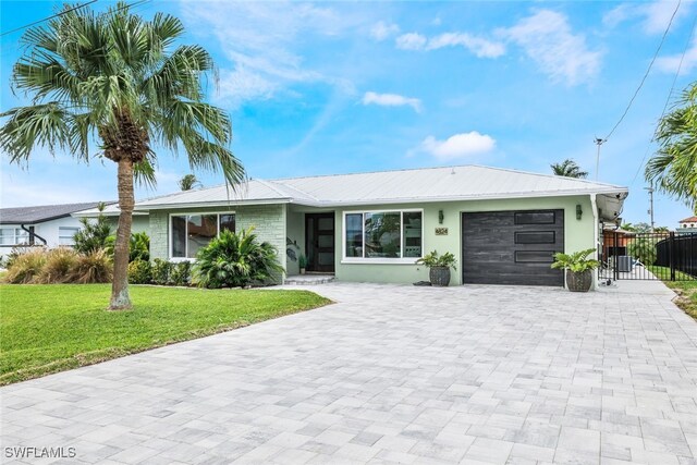 single story home featuring a garage and a front lawn