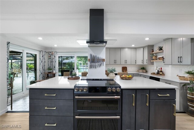 kitchen featuring gray cabinetry, a center island, light hardwood / wood-style floors, electric stove, and island exhaust hood