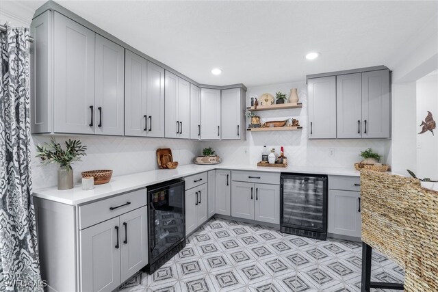 kitchen with beverage cooler, gray cabinetry, and backsplash