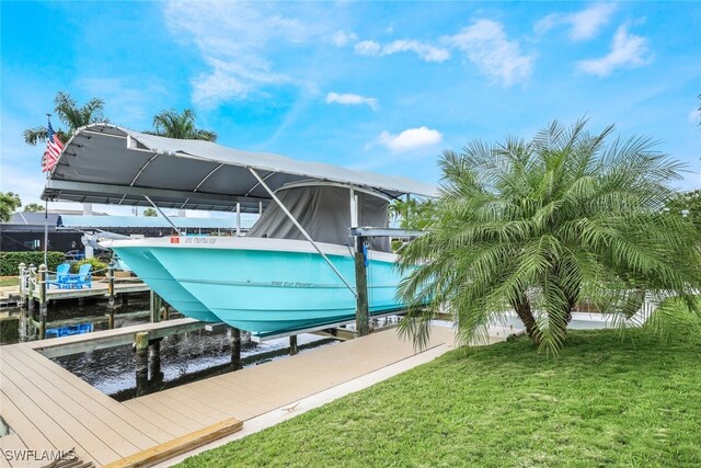 view of dock with a yard and a water view