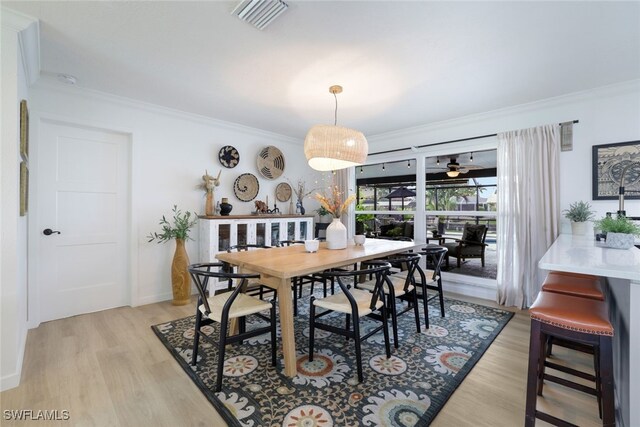 dining room featuring ceiling fan, ornamental molding, and light hardwood / wood-style floors