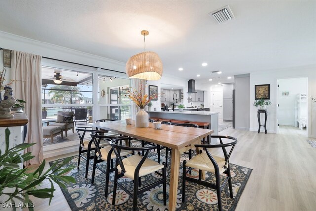 dining room featuring crown molding, a healthy amount of sunlight, ceiling fan, and light hardwood / wood-style floors