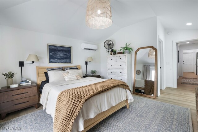 bedroom with light wood-type flooring, vaulted ceiling, and a wall unit AC