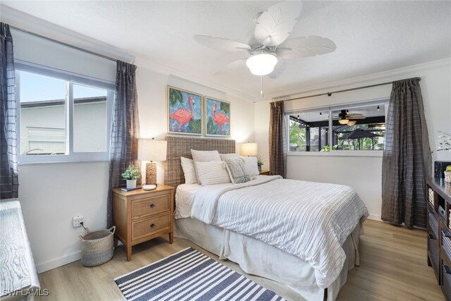 bedroom featuring crown molding, light wood-type flooring, and ceiling fan