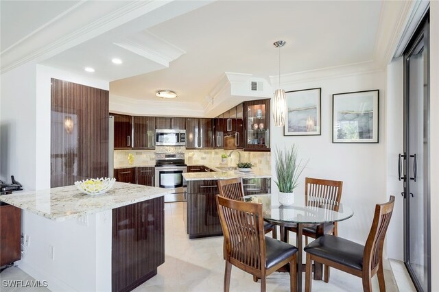 kitchen featuring ornamental molding, tasteful backsplash, a center island, appliances with stainless steel finishes, and dark brown cabinetry