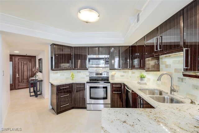 kitchen with crown molding, light stone counters, stainless steel appliances, sink, and decorative backsplash