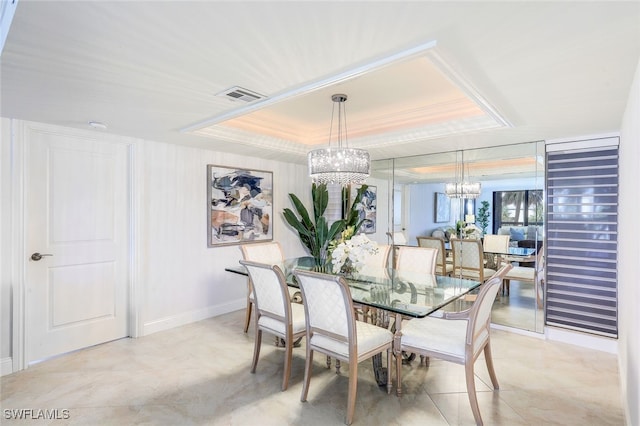 dining area featuring a tray ceiling and a chandelier