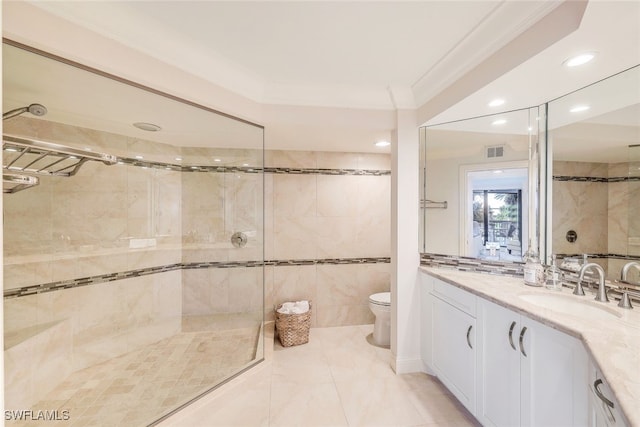 bathroom featuring vanity, toilet, ornamental molding, and a tile shower