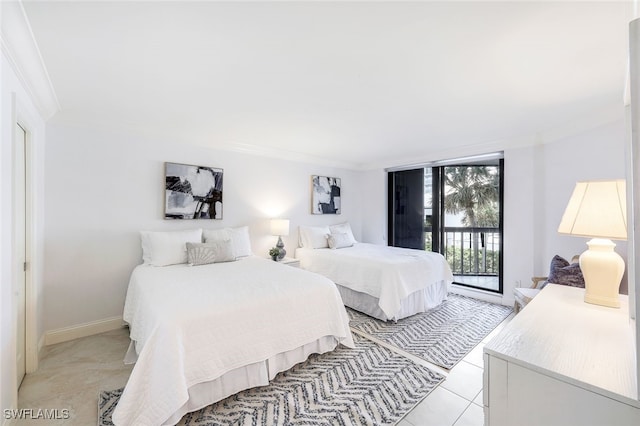 tiled bedroom featuring crown molding and access to outside