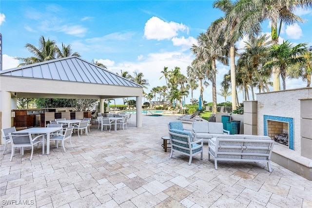 view of patio / terrace featuring a community pool, an outdoor living space with a fireplace, and a gazebo