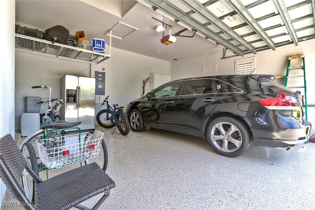 garage with stainless steel fridge with ice dispenser and a garage door opener