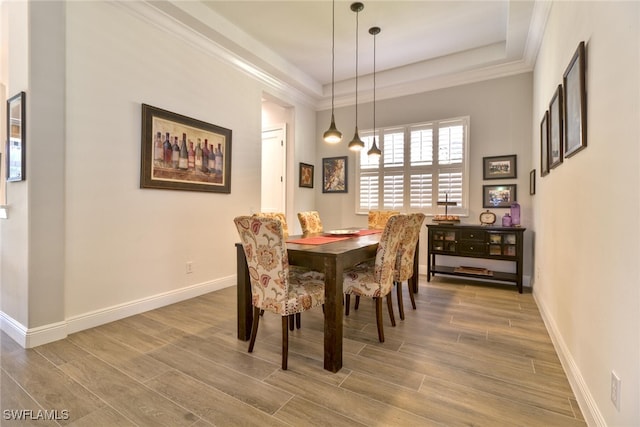 dining space featuring ornamental molding and a raised ceiling