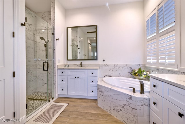 bathroom with vanity and shower with separate bathtub