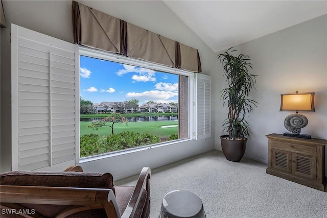 sitting room featuring a water view, carpet floors, and lofted ceiling