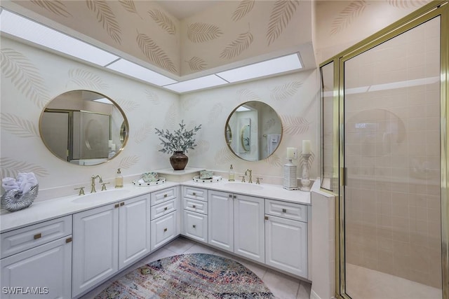 bathroom featuring tile patterned flooring, walk in shower, a skylight, and vanity