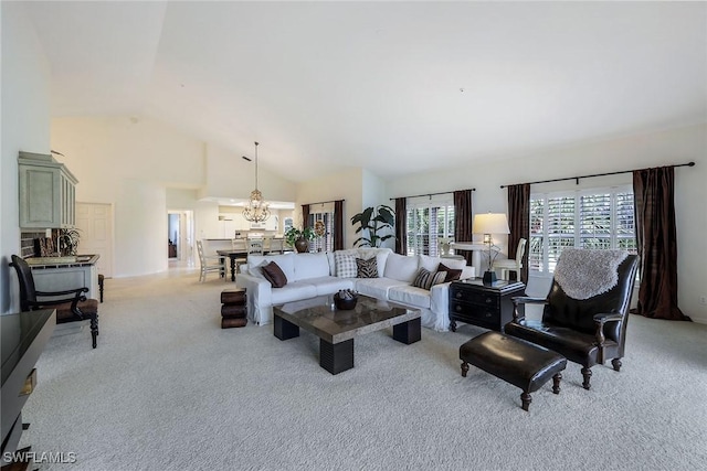 living room with vaulted ceiling, a chandelier, and light carpet