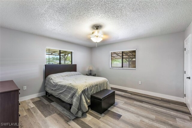 bedroom featuring a textured ceiling, ceiling fan, and hardwood / wood-style floors