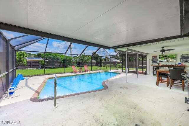 view of pool featuring a lawn, ceiling fan, a lanai, and a patio