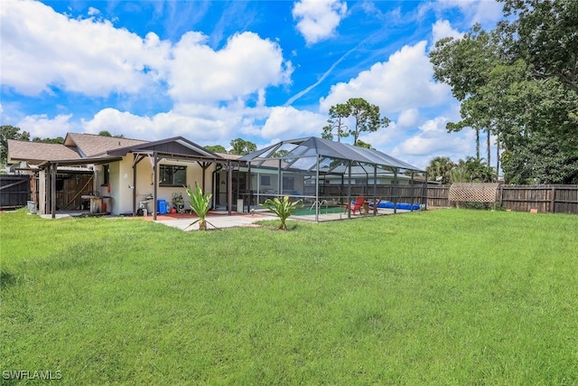 view of yard with glass enclosure, a patio, and a pool