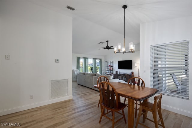 dining room with ceiling fan with notable chandelier and light hardwood / wood-style flooring